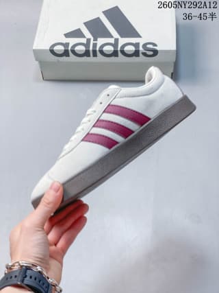 Side view showing the off-white upper, burgundy three-stripe detail, and gum-colored sole.