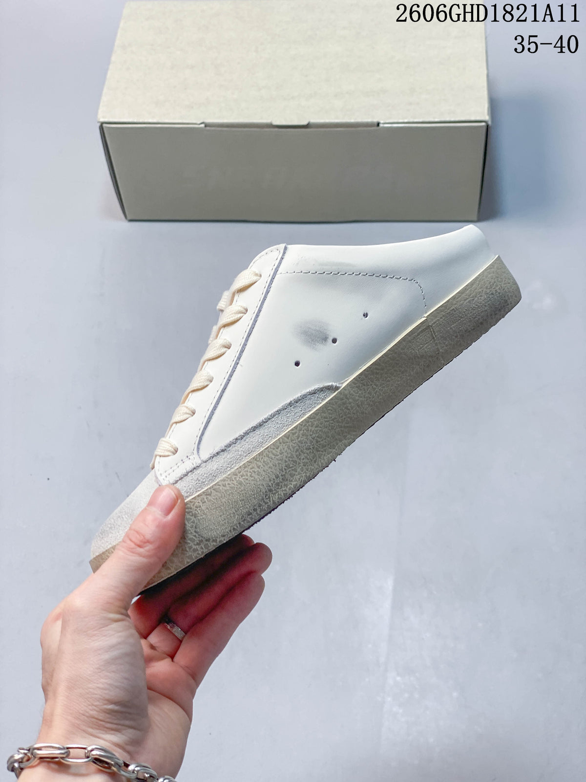Side view of the white sneaker showing scuff-style marks and a beige-toned sole