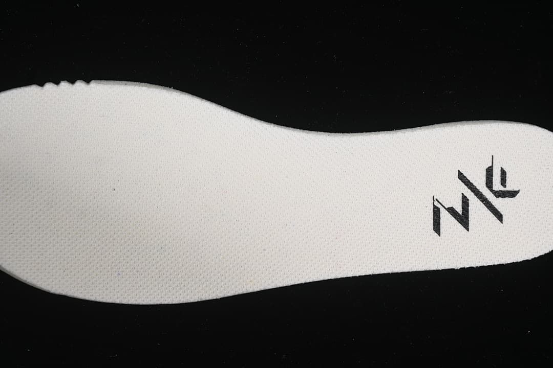 Close-up of textured shoe insert with a black logo