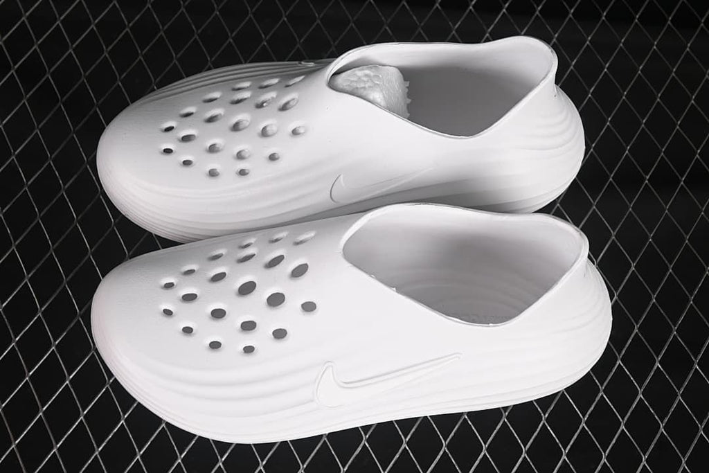 Pair of white perforated clog slides shown from above and side