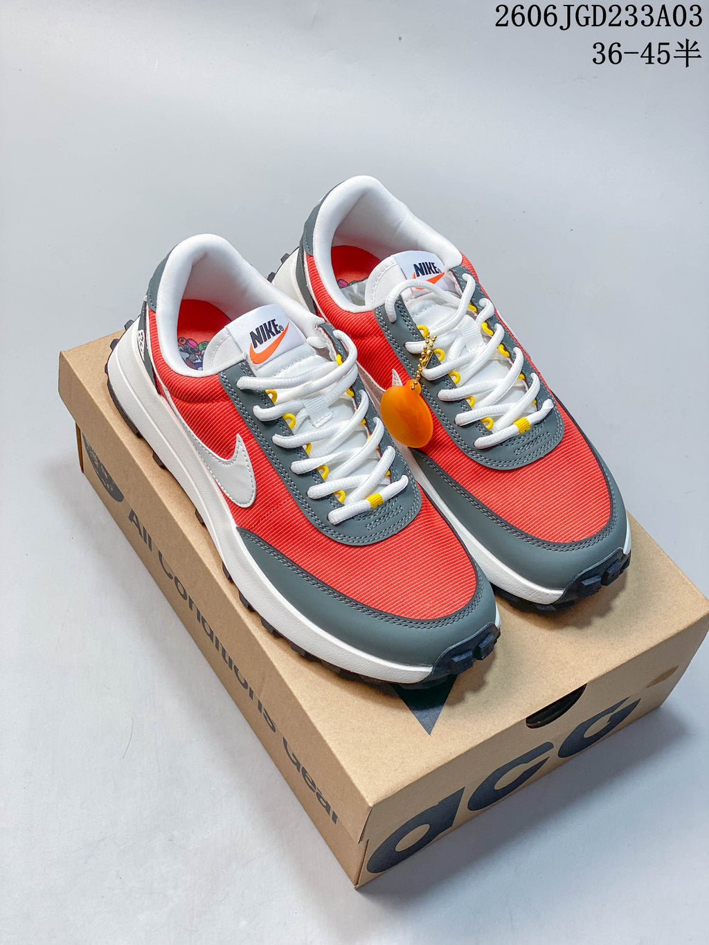 Red and gray Nike ACG low-top sneakers shown on a box