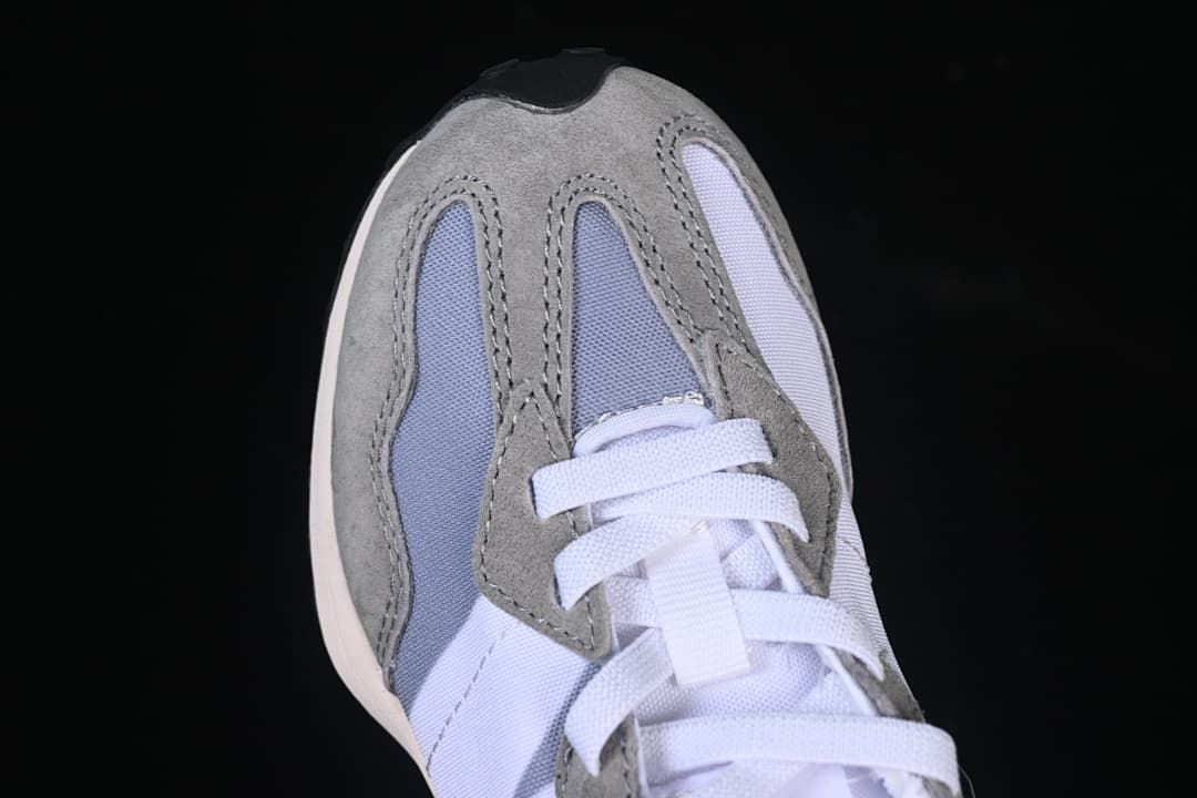 Top view of the sneaker toe, grey overlays, and white laces.