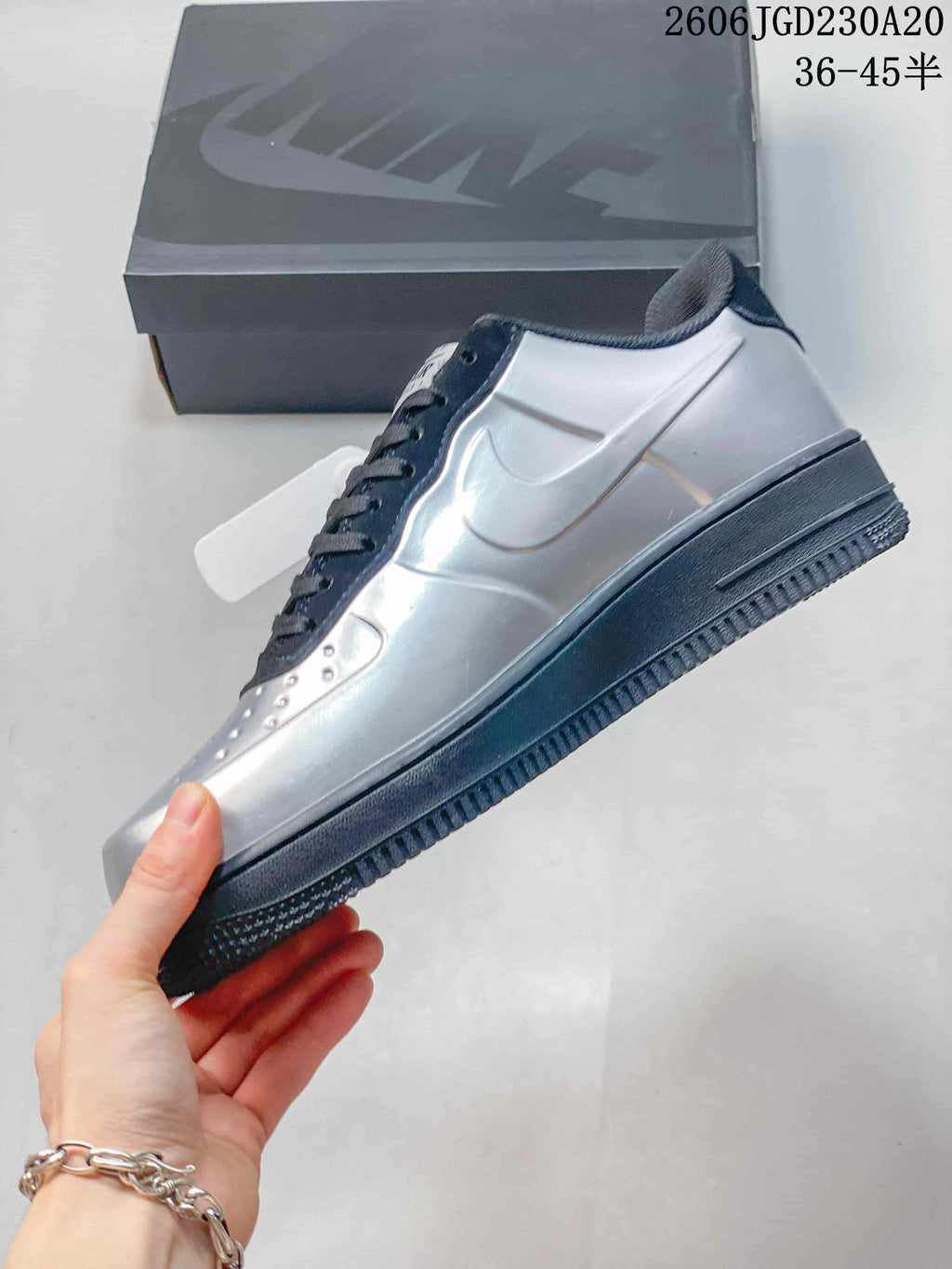 Side profile of a silver Nike Air Force 1 sneaker with navy accents