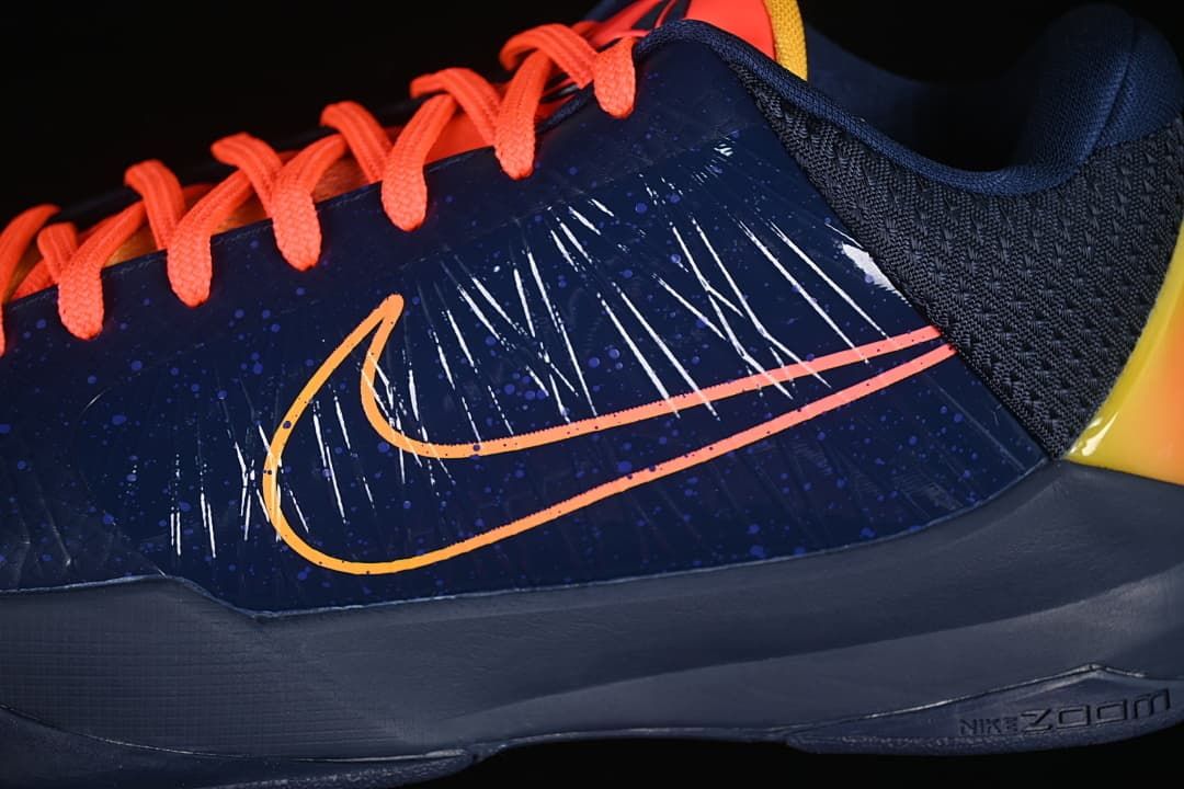 Close-up of the side Swoosh, navy upper, and coral laces.