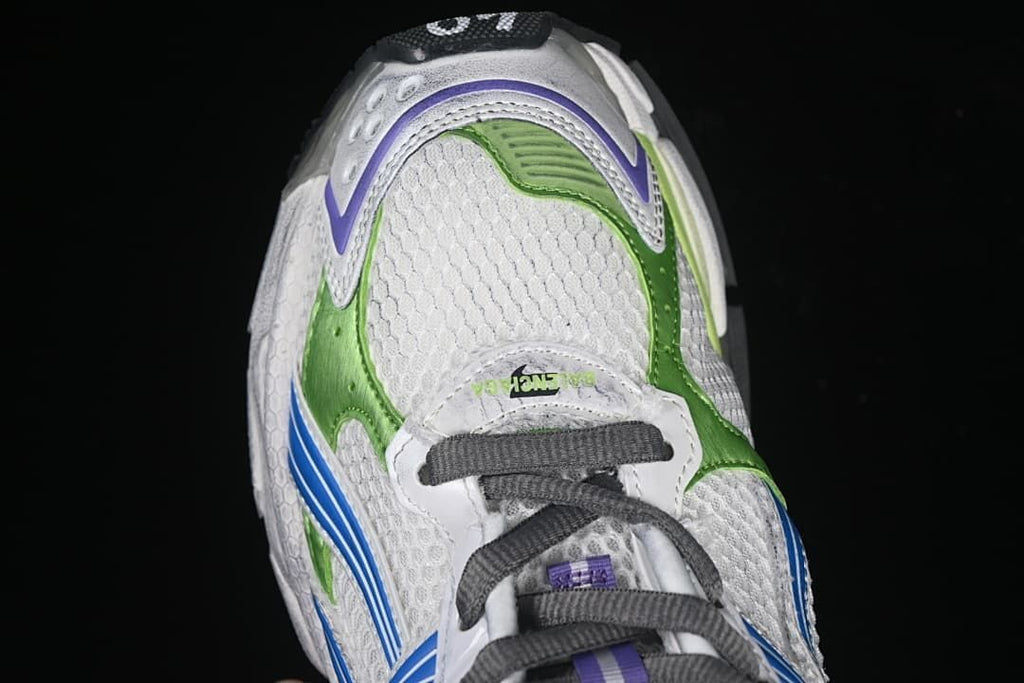 Top-down view of the white sneaker with green and purple toe accents and dark laces