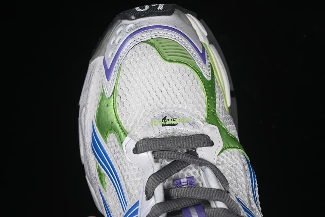 Top-down view of the white sneaker with green and purple toe accents and dark laces
