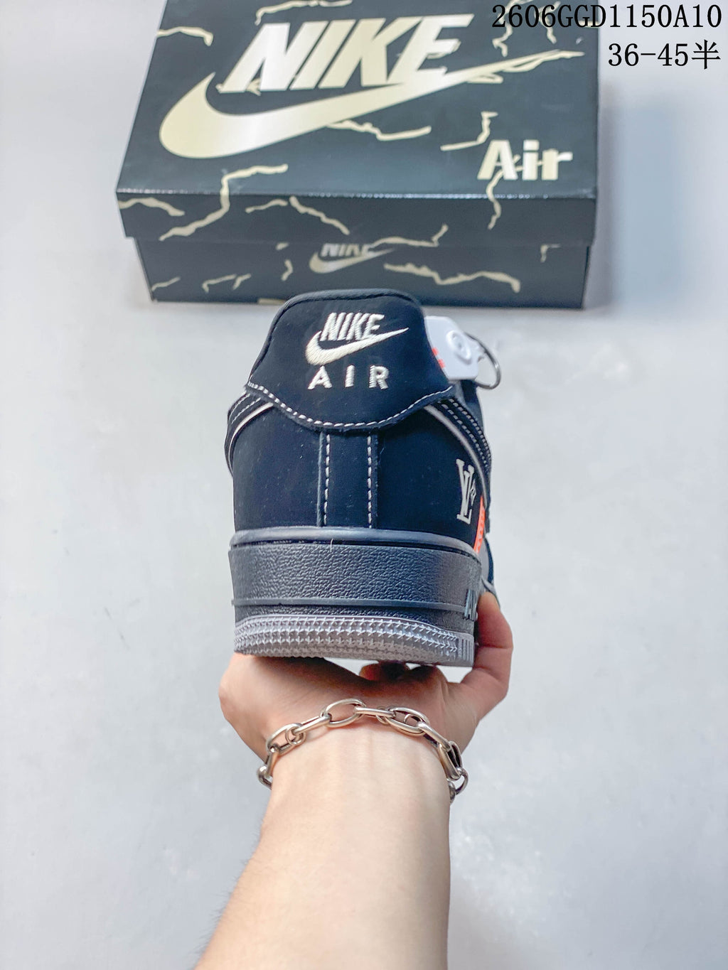 Rear view of a navy sneaker showing heel branding, stitching and gray outsole