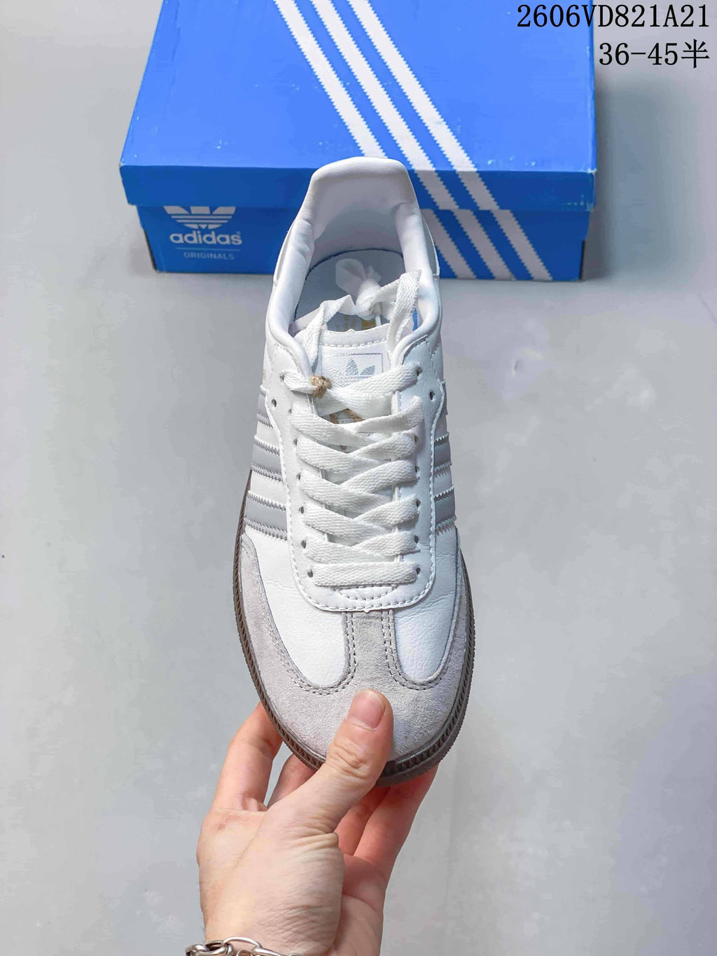 Front view of a white sneaker with grey toe overlay and white laces