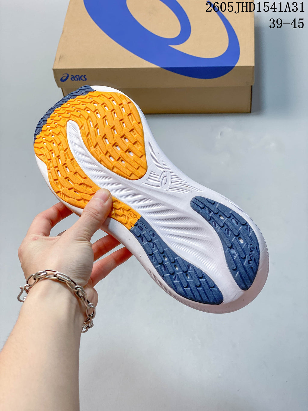 Underside of a gray running shoe showing orange and navy outsole sections