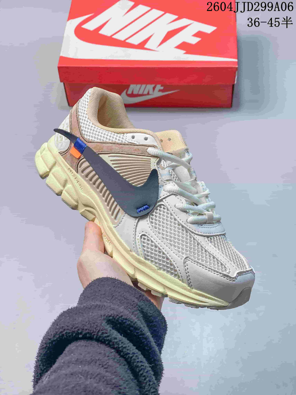 Side view of a light-colored Nike Zoom Vomero 5 sneaker with a dark swoosh and pale-toned sole.