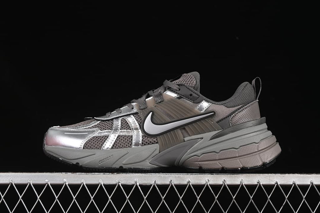 Side view of silver-gray Nike V2K Run sneakers with metallic-look overlays and a chunky sole