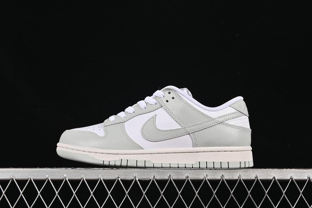 Side view of a white and light grey low-top Nike SB Dunk sneaker