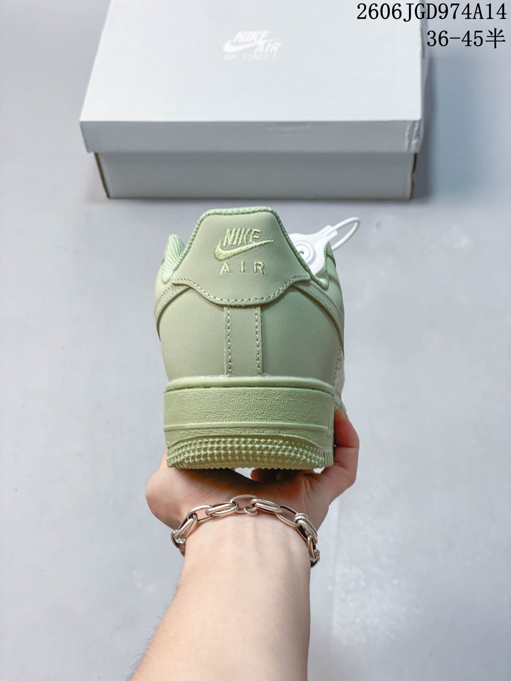 Rear view of a pale green sneaker with a raised heel and stitched details