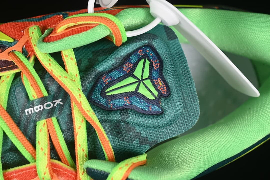 Close-up of green shoe tongue logo and orange and neon-green laces