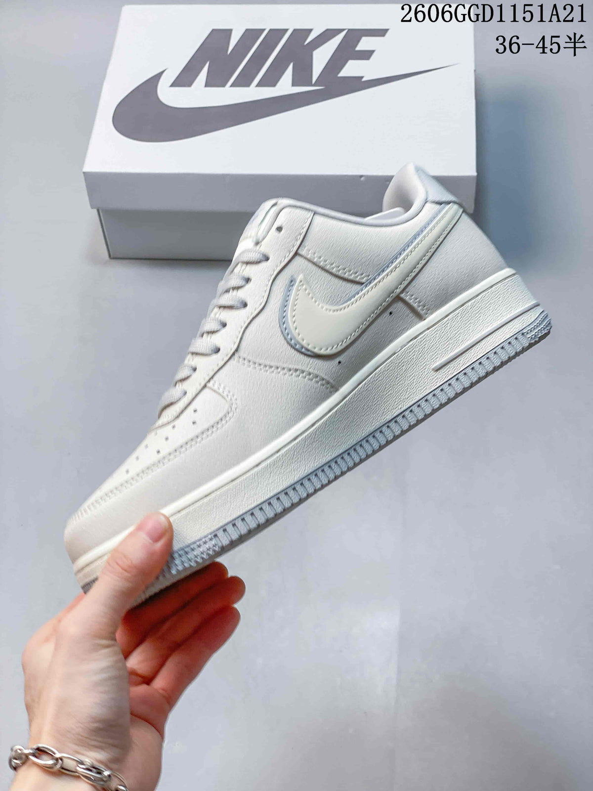 Side profile of a cream Nike Air Force 1 Low with a pale blue-edged Swoosh