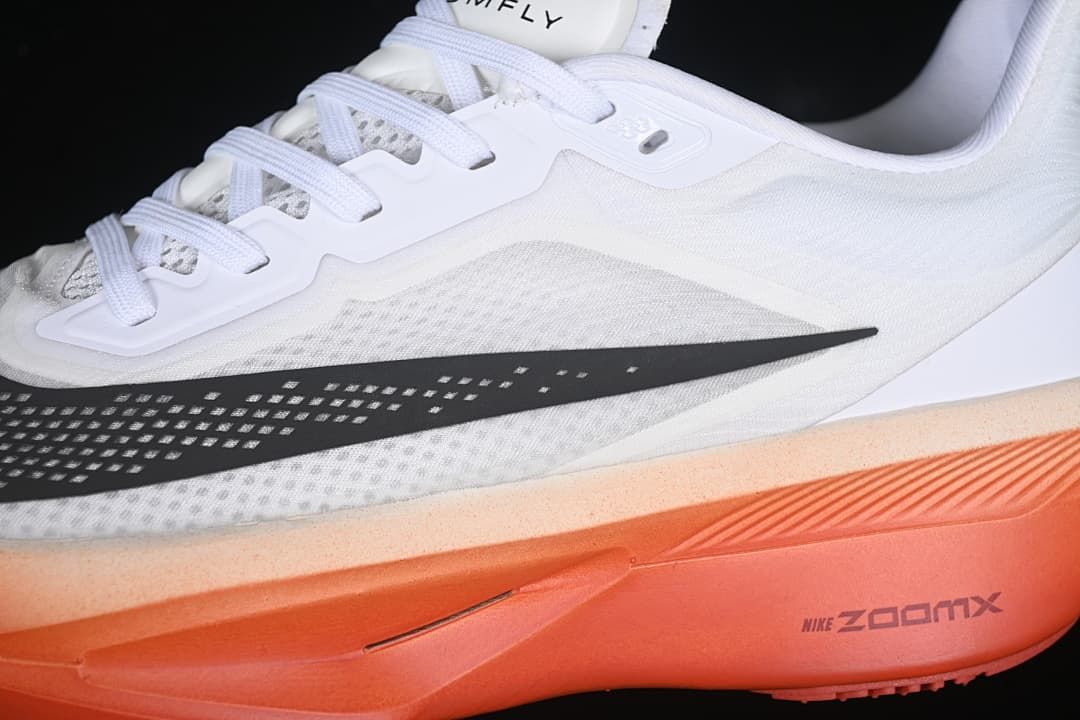 Close-up of the mesh-look upper, black swoosh, laces and orange sole