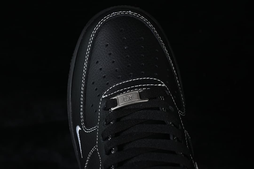Top view of perforated toe, black laces, and metal-tone lace tag