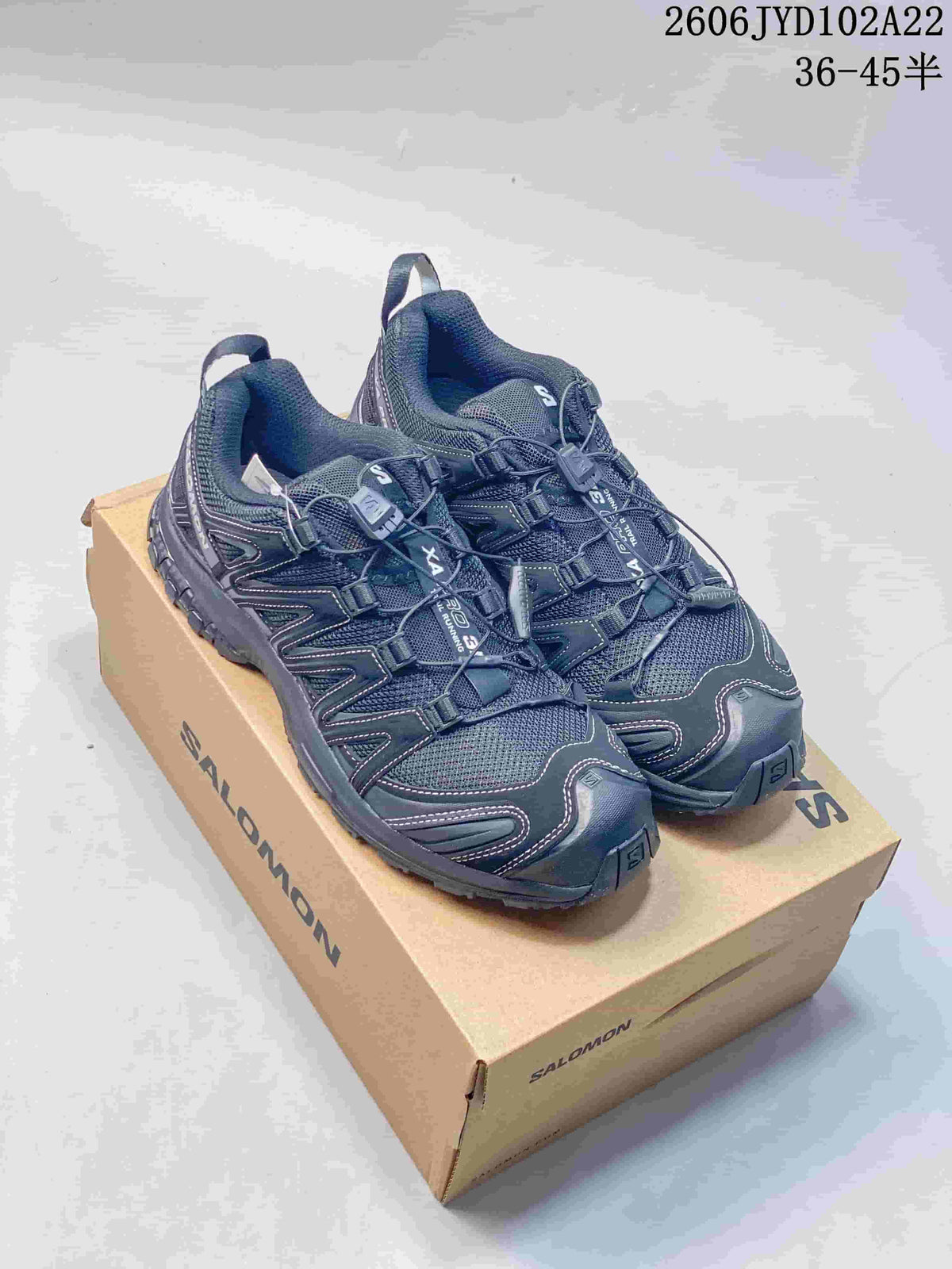 Pair of dark gray Salomon XA Pro 3D low-top shoes displayed on a shoe box.