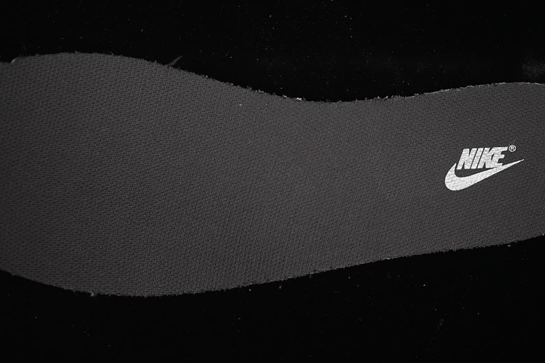 Close-up of a dark textured shoe component with a Nike logo
