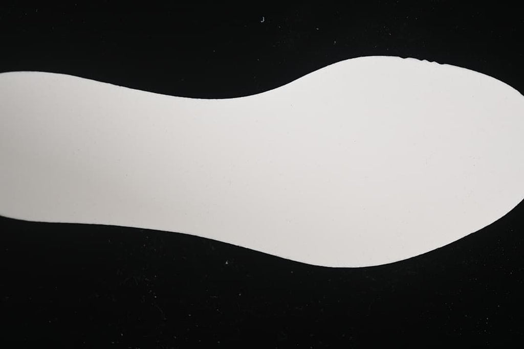 White shoe-shaped outsole or insert shown against a black background.