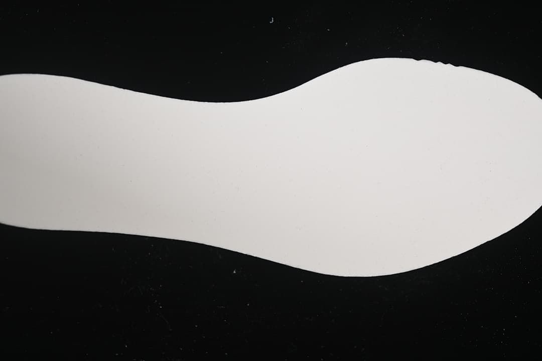 White shoe-shaped outsole or insert shown against a black background.