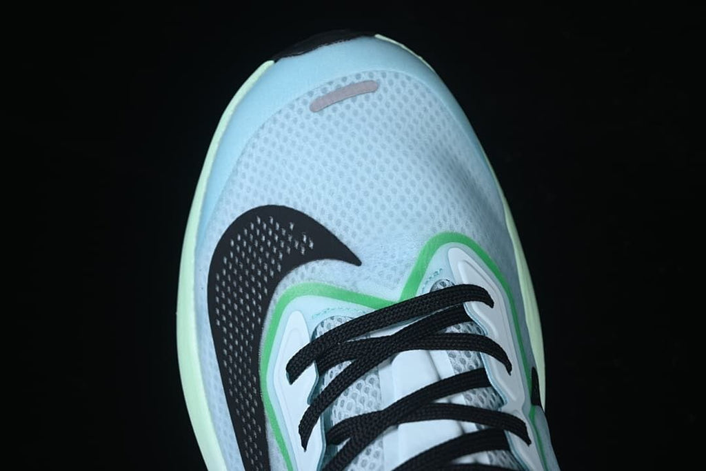 Top view of the shoe's mesh-patterned toe, laces, and black Swoosh.