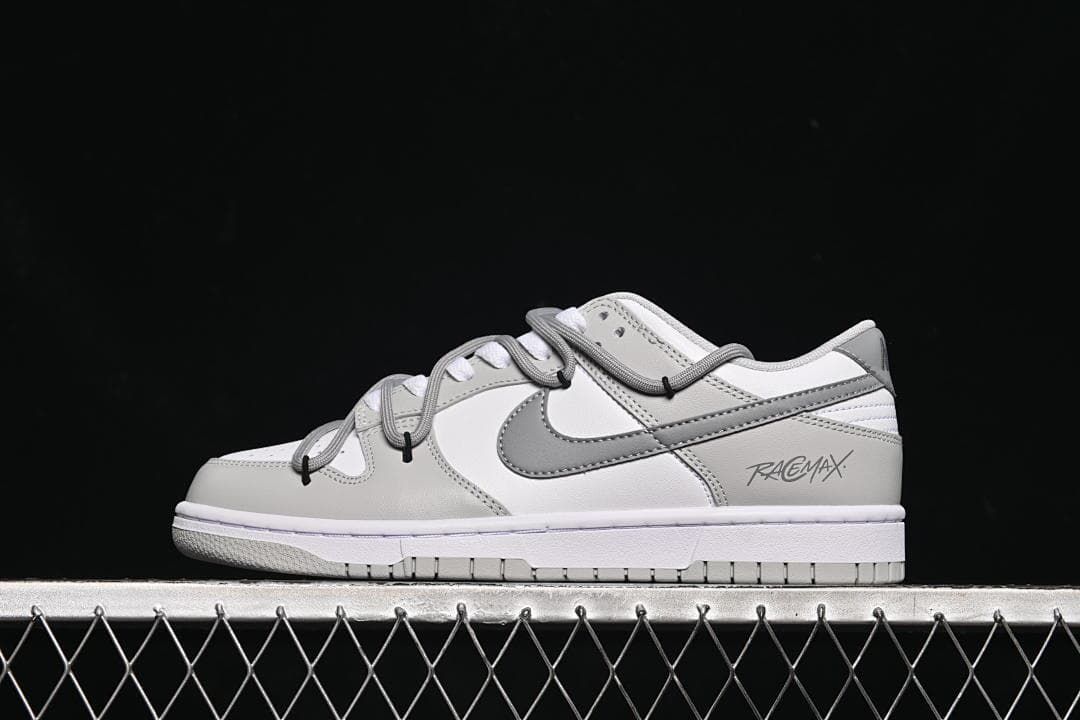 Side view of a white and grey low-top Dunk sneaker with cord-style lacing