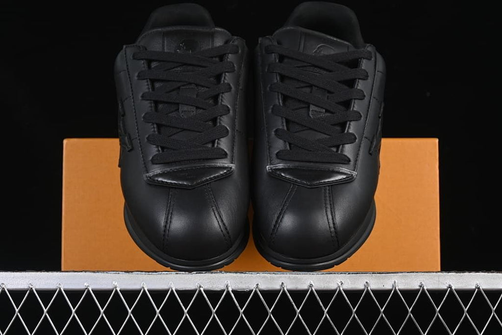 Front view of the pair of black lace-up sneakers
