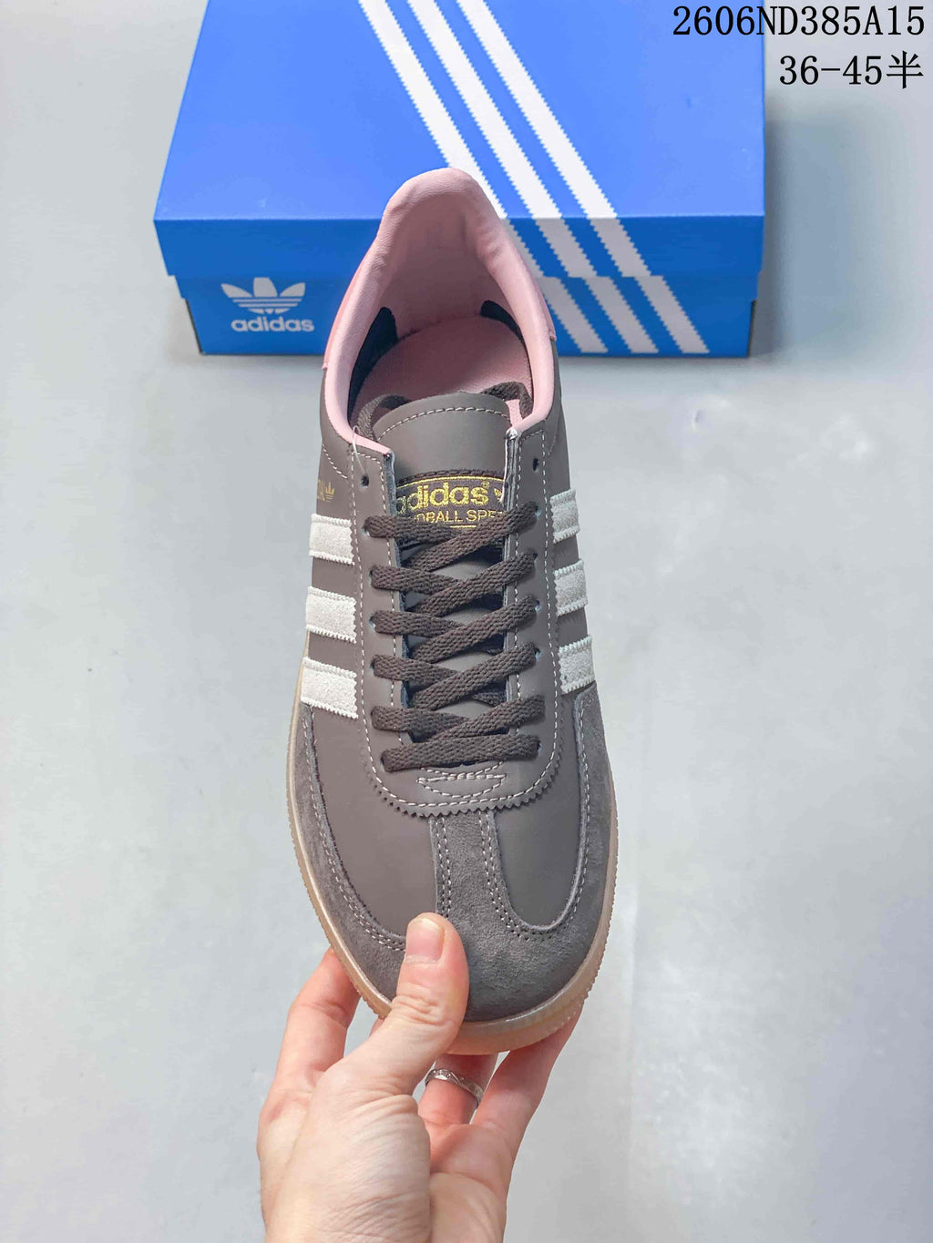Top view of the sneaker showing dark laces, a grey upper and pink lining.