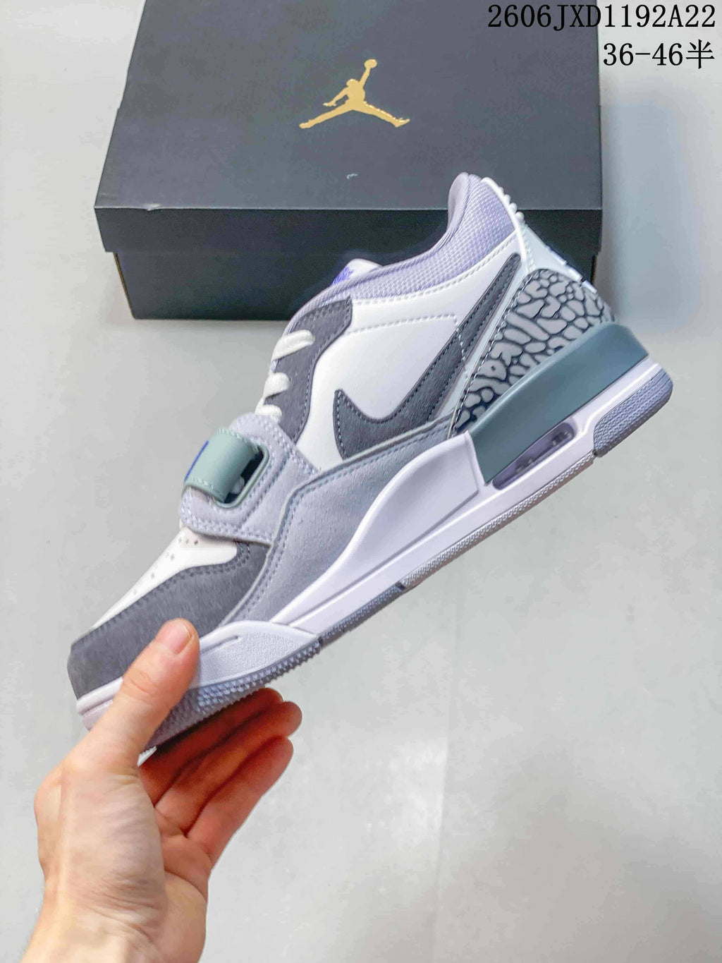 Side profile of the grey and white Jordan Legacy 312 Low showing its heel panel and midsole.