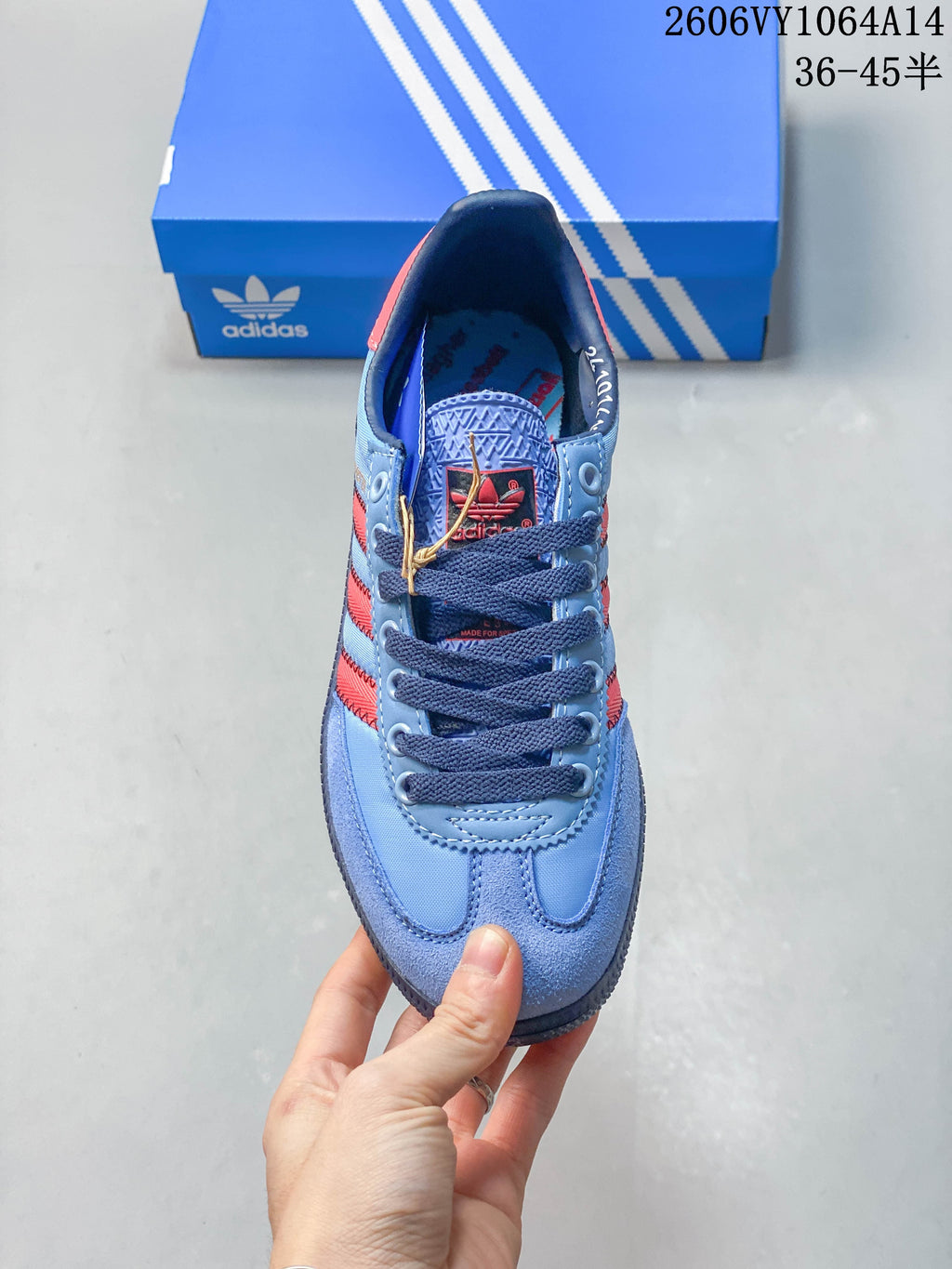 Front view of the lace-up sneaker in light blue, red and navy