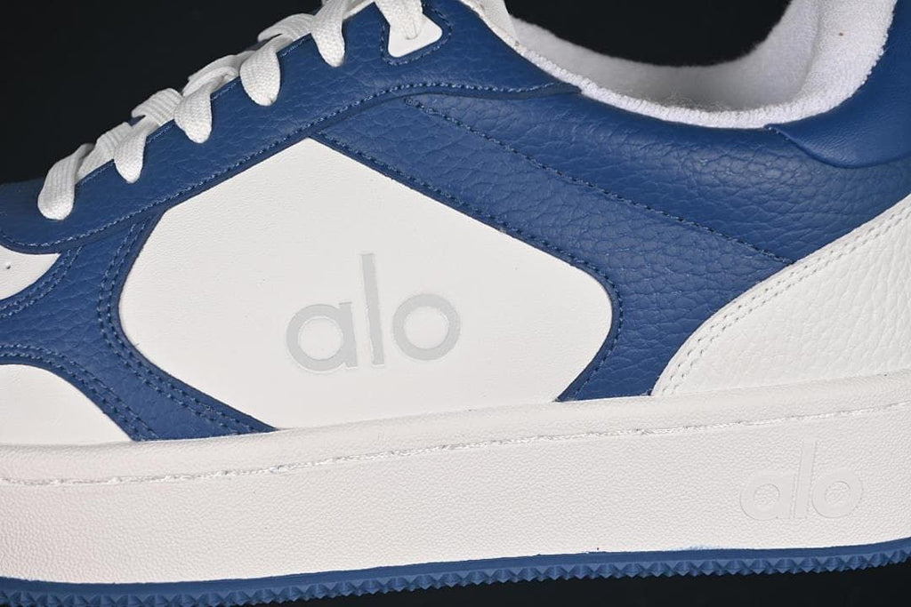 Close-up of the navy and white side panels, stitching, and embossed logo