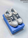 Pair of silver and white Adidas Originals Pr Sftm sneakers on a blue box