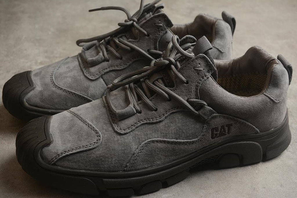 Pair of gray CAT Tramp Hike Low sneakers viewed from the side.
