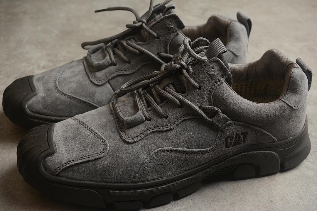 Pair of gray CAT Tramp Hike Low sneakers viewed from the side.