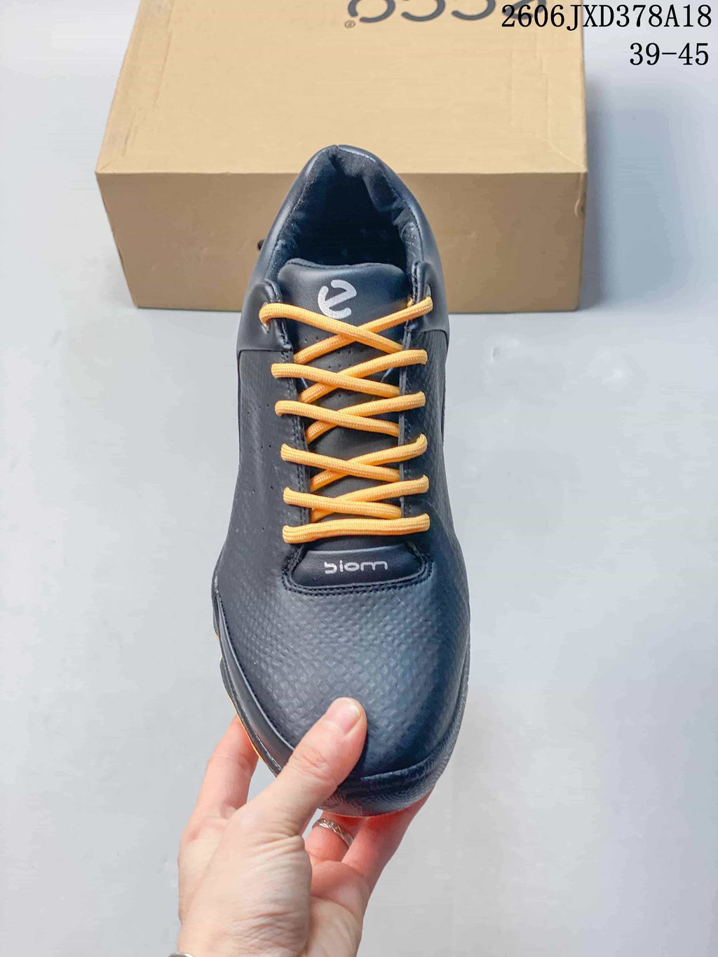 Top view of a black ECCO BIOM sneaker with bright orange laces.