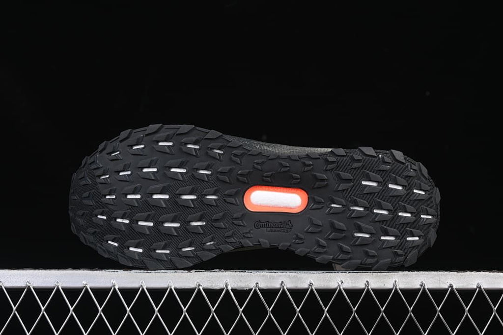 View of the black patterned outsole with orange center detail