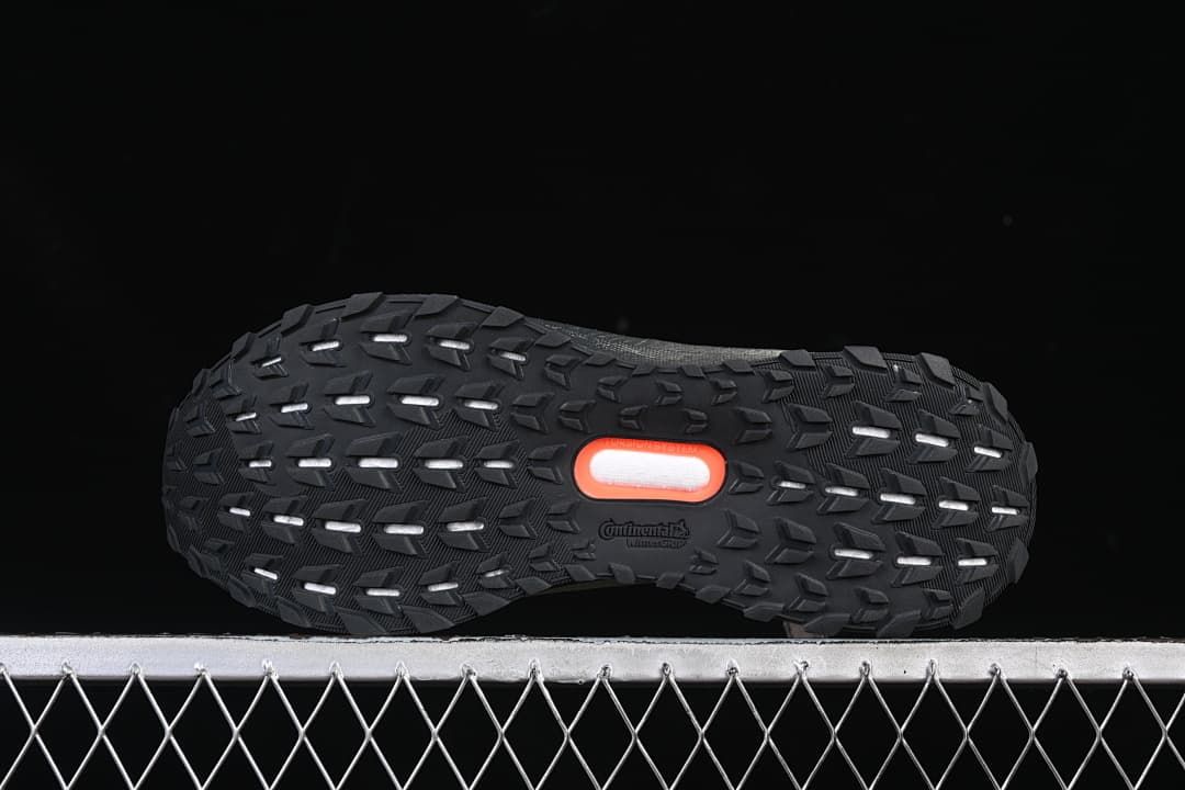 View of the black patterned outsole with orange center detail