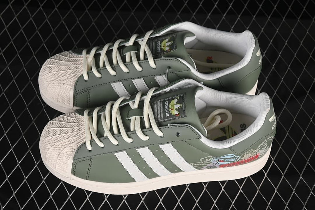 Pair of green adidas Superstar II sneakers with cream shell toes and white stripes.