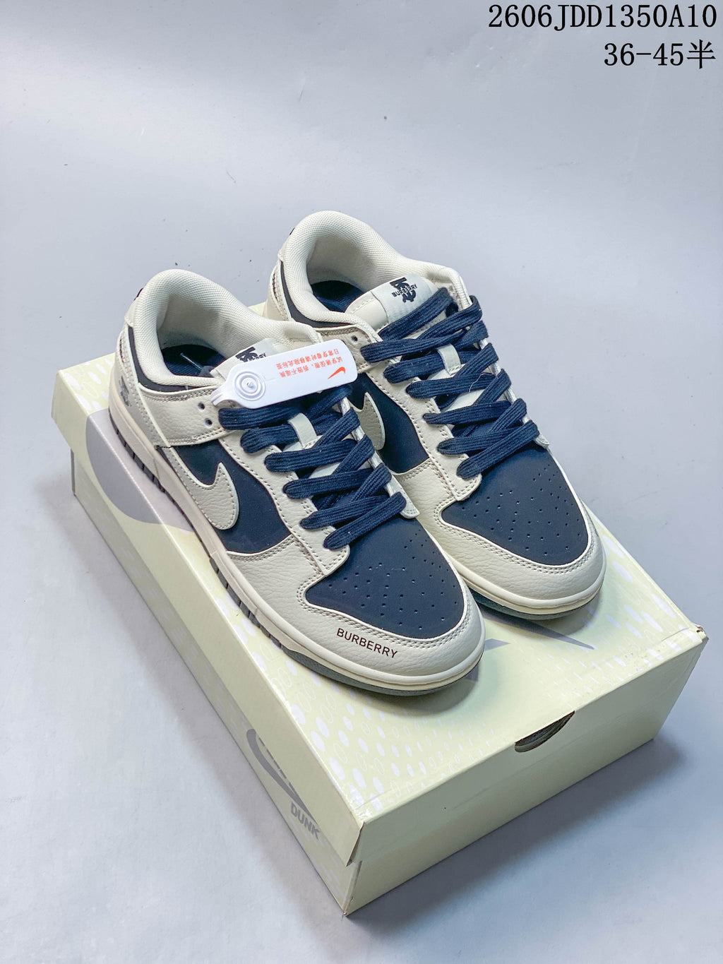 Pair of navy and off-white low-top sneakers with Burberry lettering and a Nike-style Swoosh