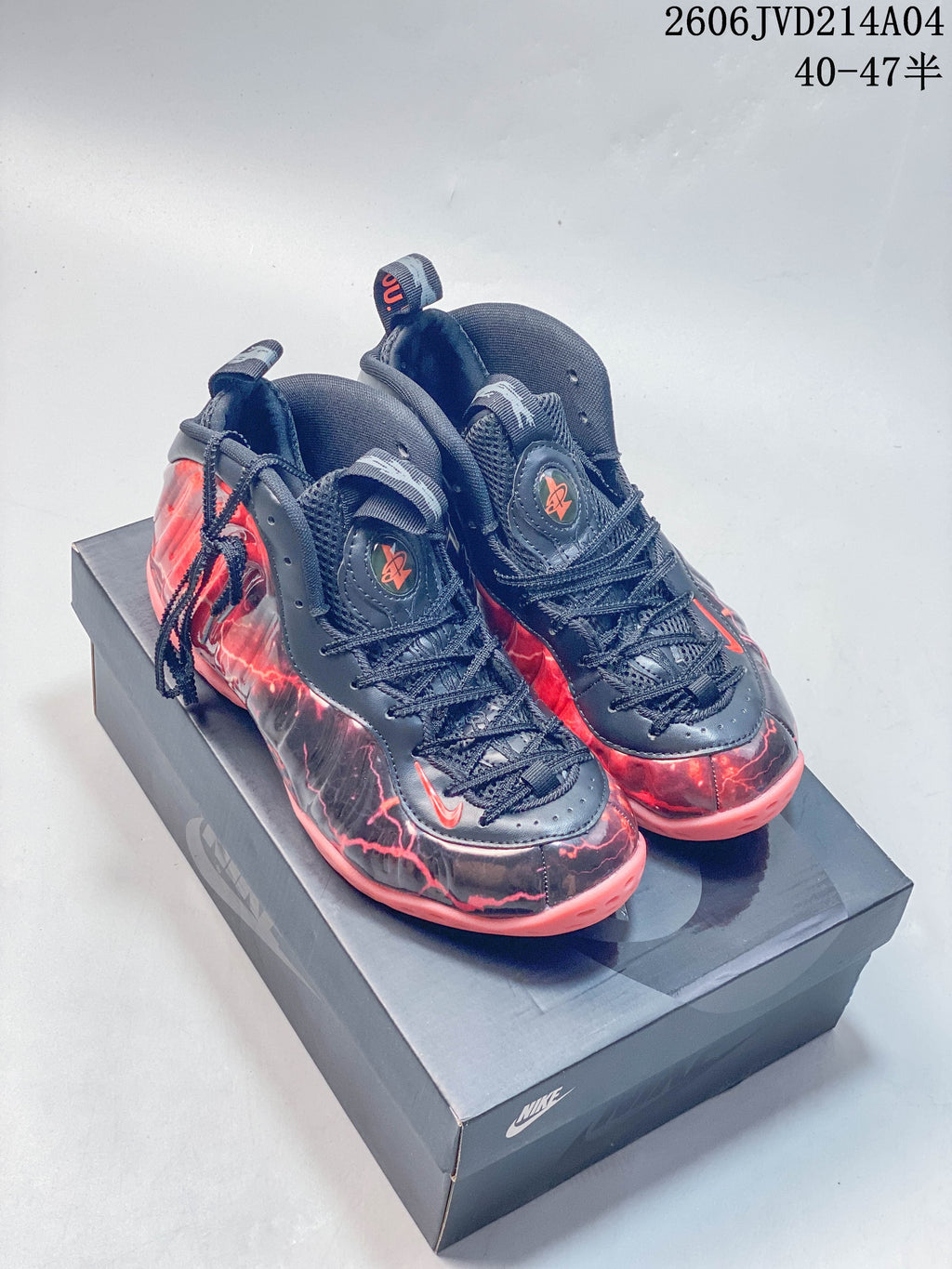 Pair of navy and red Nike Air Foamposite Pro shoes shown from the front on a box.