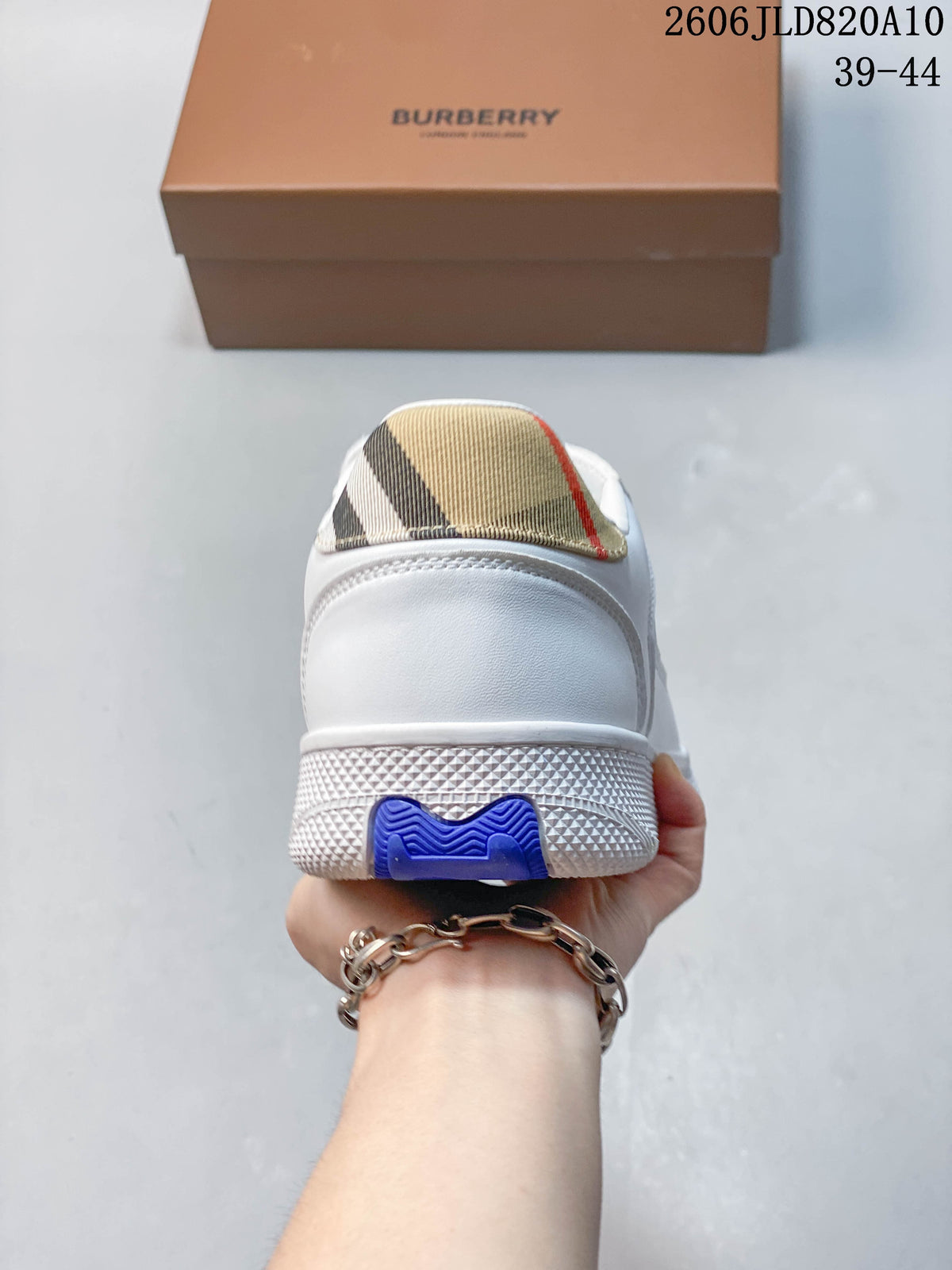 Rear view of a white sneaker with a check-pattern heel tab and blue sole accent