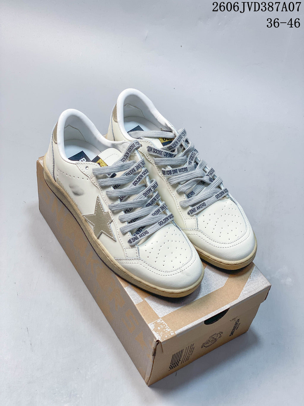 Pair of white Super-Star low-top sneakers with silver star details, gray printed laces, and distressed-look beige midsoles