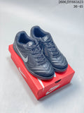 Pair of dark gray Nike Gato low-top sneakers displayed on a red shoebox