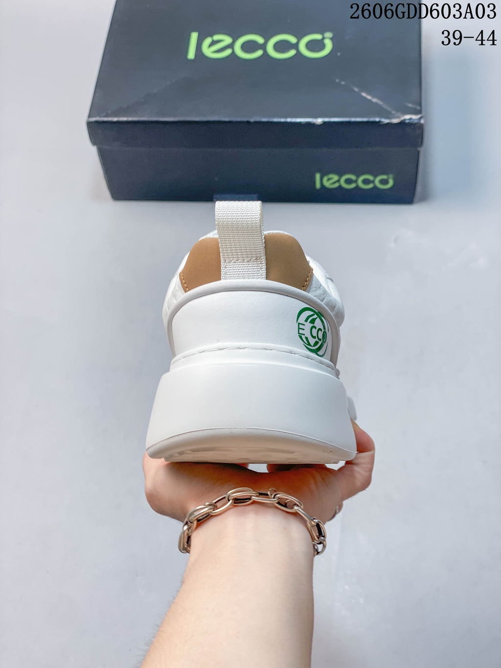 Rear view of the white sneaker with heel pull tab and logo detail; image overlay states sizes 39–44.