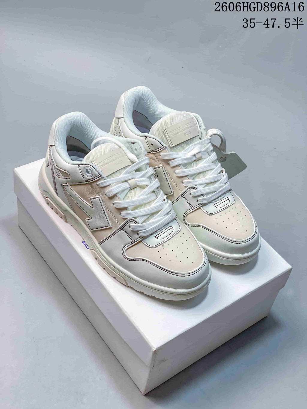 Pair of white low-top sneakers with contrast stitching, perforated toe panels and a chunky sole