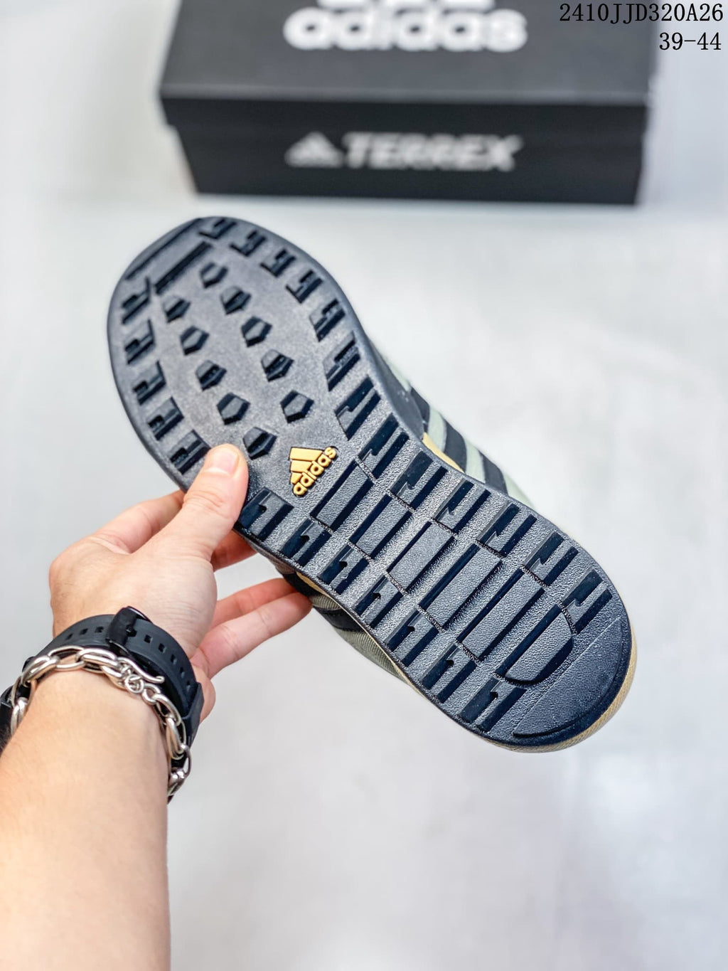 Close-up of the dark lugged outsole on an adidas Daroga shoe.
