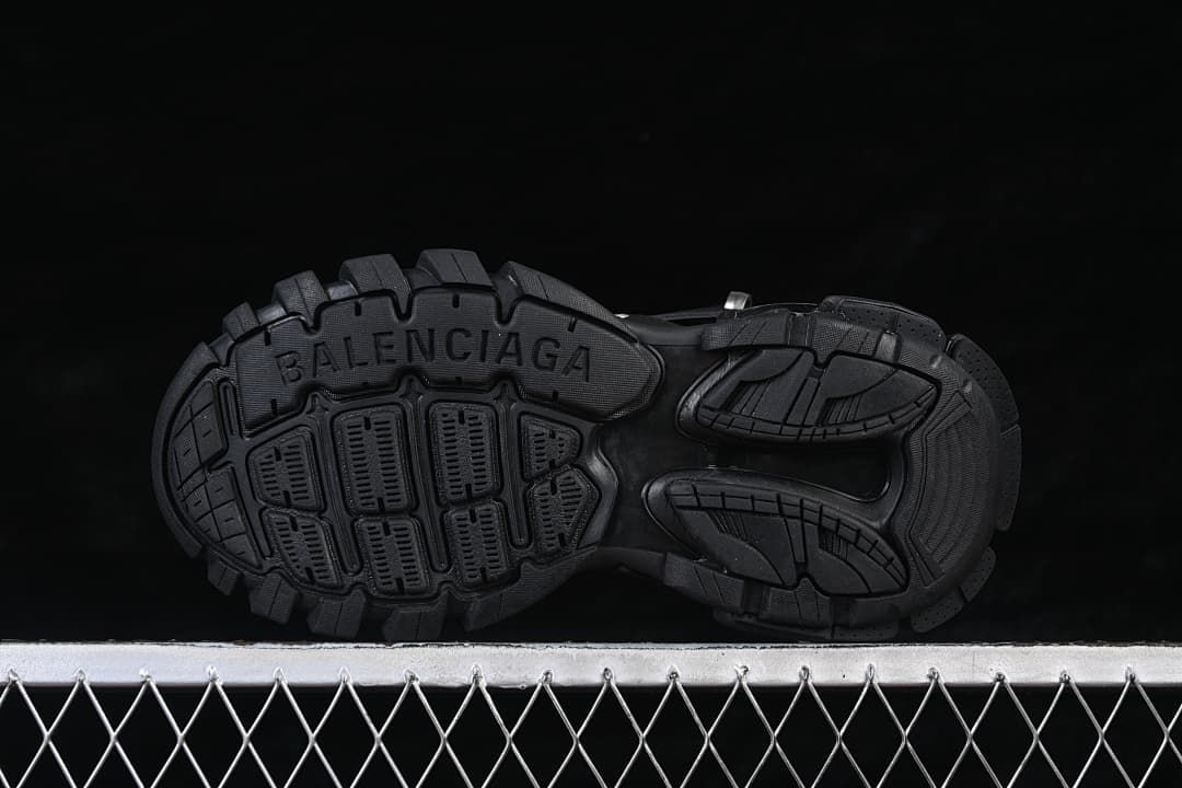 Underside view of the deeply patterned black sneaker tread