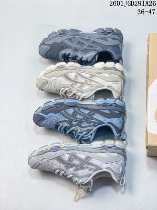 Four ASICS GEL-NYC RGD sneakers arranged sole-to-sole, showing dark blue-gray, white, blue, and light-gray color combinations; image text shows code 2601JGD291A26 and sizes 36–47.