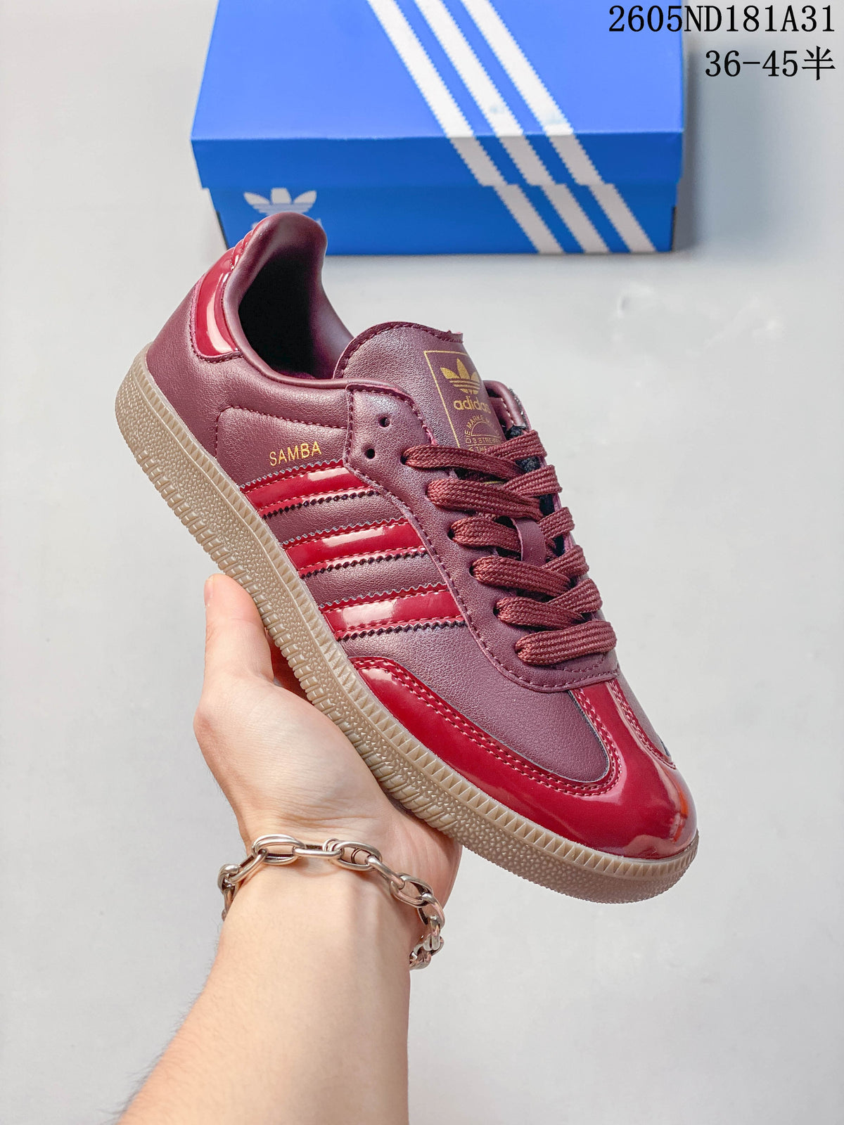 Close side view of a burgundy and red sneaker with three stripes